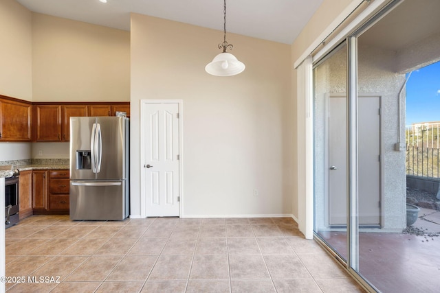 kitchen featuring appliances with stainless steel finishes, decorative light fixtures, brown cabinets, and high vaulted ceiling