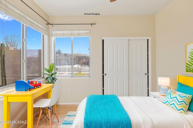 bedroom featuring baseboards, wood finished floors, and a closet