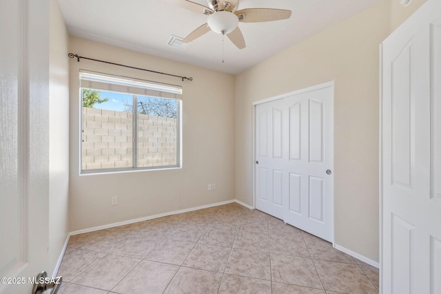 unfurnished bedroom with visible vents, a ceiling fan, baseboards, and light tile patterned floors