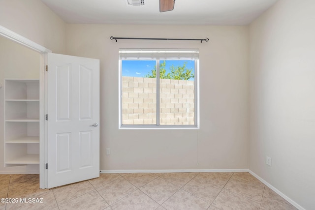 unfurnished bedroom featuring baseboards, ceiling fan, light tile patterned floors, and visible vents