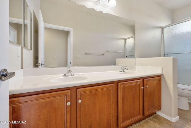 full bath featuring double vanity, toilet, a sink, and tile patterned flooring
