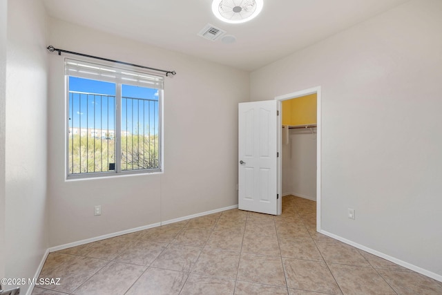 unfurnished bedroom featuring baseboards, visible vents, and a spacious closet