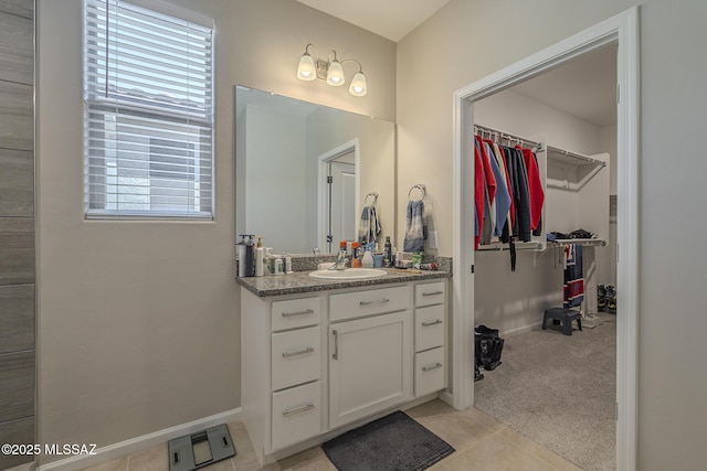 5369 S Sierra Prieta Trl, Tucson, AZ 85747 - bathroom featuring tile patterned floors, a spacious closet, vanity, and baseboards