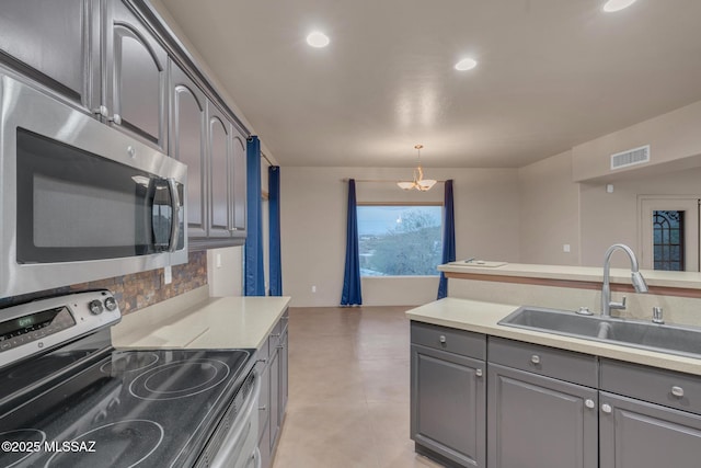 kitchen featuring a sink, visible vents, light countertops, stainless steel appliances, and gray cabinetry