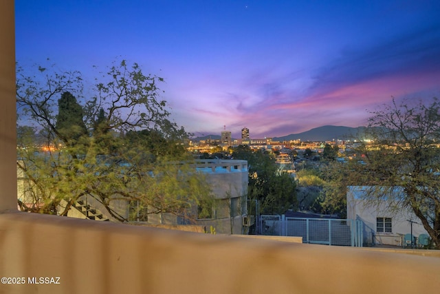 balcony at dusk featuring a mountain view