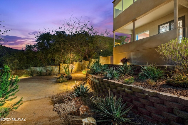 yard at dusk with fence and a patio area