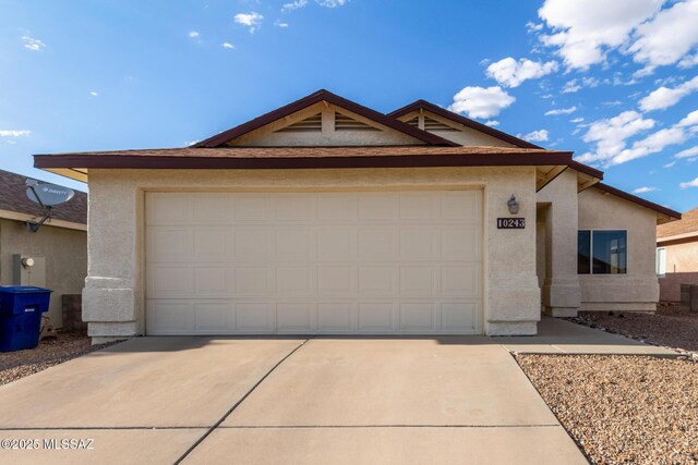 ranch-style house with an attached garage, stucco siding, and concrete driveway