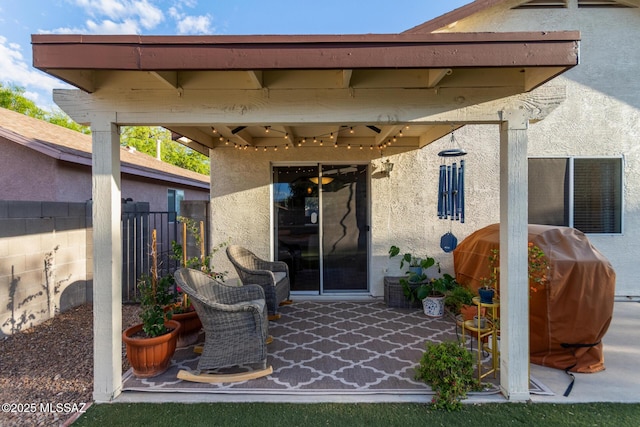 view of patio with fence and a grill