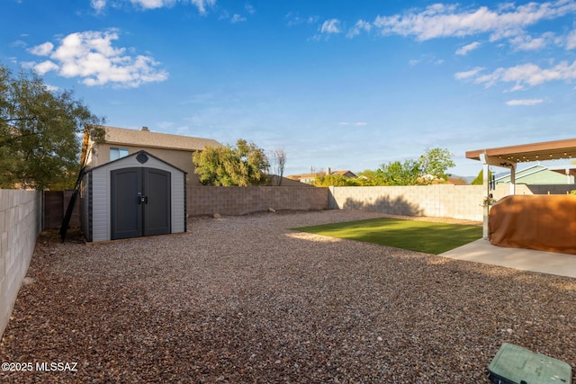 view of yard with an outbuilding, a shed, and a fenced backyard