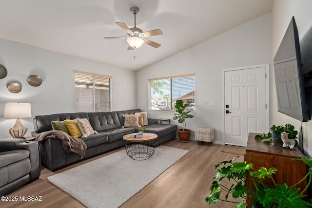 living room featuring light wood-type flooring, baseboards, ceiling fan, and vaulted ceiling