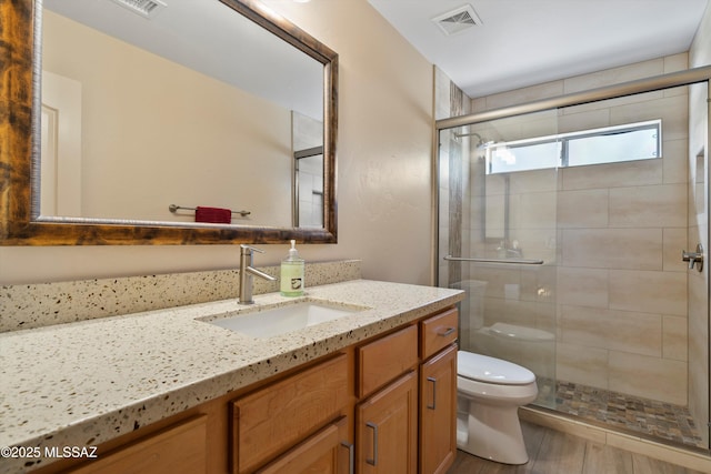37561 S Desert Sun Dr, Saddlebrooke, AZ 85739 - bathroom featuring a shower stall, visible vents, toilet, wood finished floors, and vanity