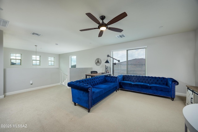 living room featuring baseboards, a ceiling fan, visible vents, and light colored carpet
