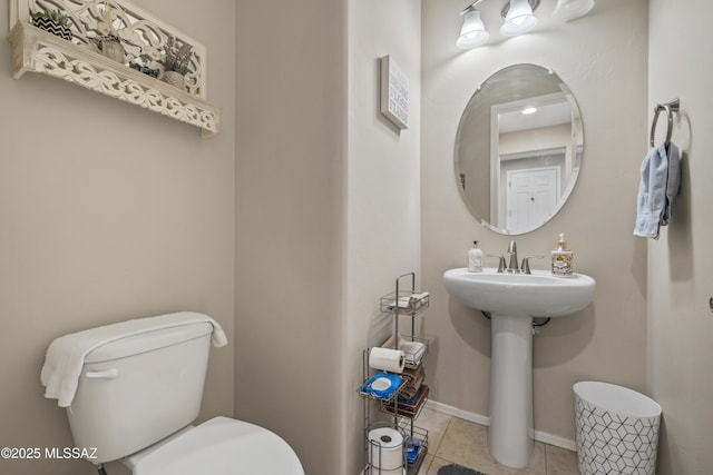 half bathroom with tile patterned floors and toilet