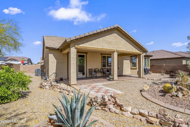 rear view of property featuring a fenced backyard, stucco siding, a patio area, and central air condition unit