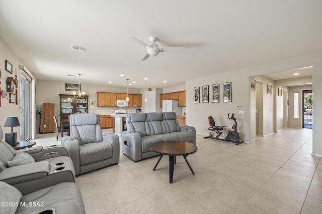 living room featuring recessed lighting, light tile patterned floors, visible vents, baseboards, and ceiling fan with notable chandelier