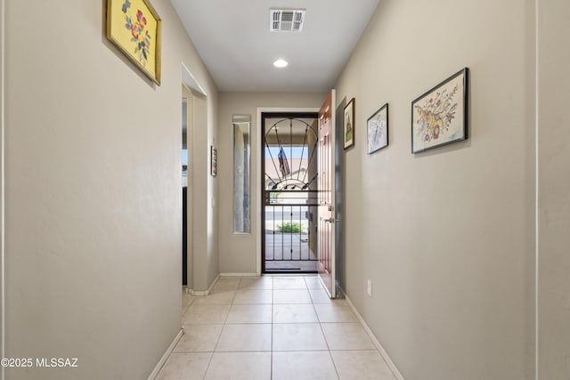 doorway with light tile patterned floors, visible vents, recessed lighting, and baseboards