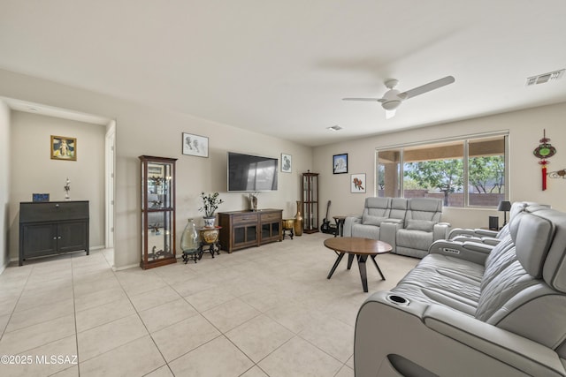living room featuring light tile patterned floors, visible vents, ceiling fan, and baseboards
