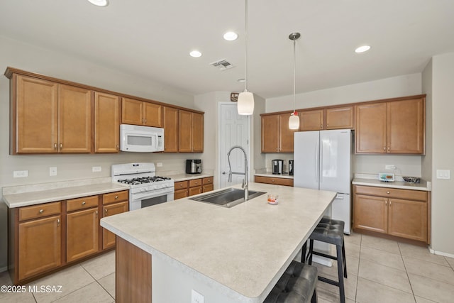kitchen with light tile patterned floors, visible vents, a sink, and white appliances
