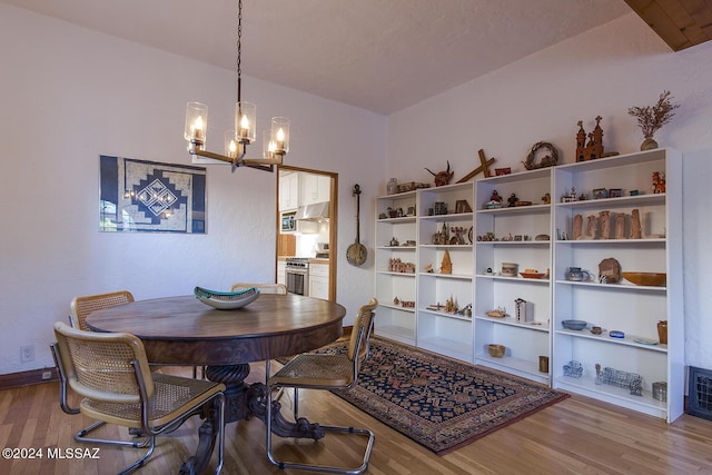 dining room with wood finished floors and a notable chandelier