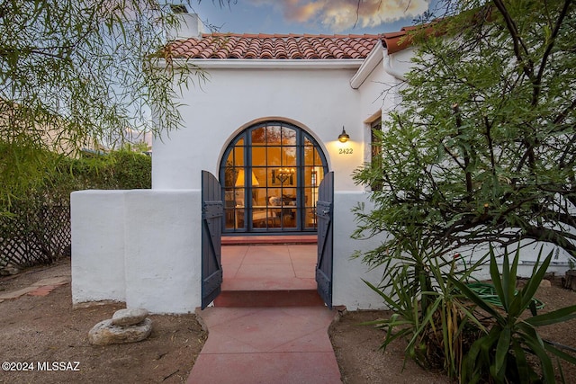 property entrance featuring stucco siding and a tiled roof