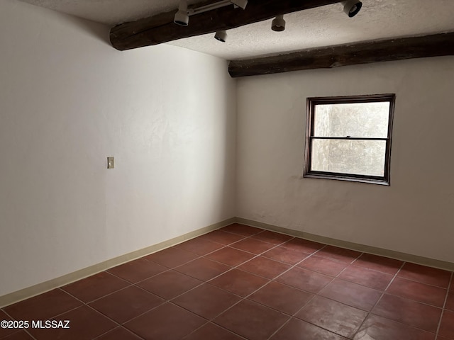 empty room with dark tile patterned floors and a textured ceiling