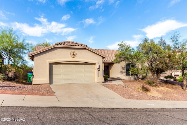 mediterranean / spanish-style home with stucco siding, concrete driveway, a tiled roof, and an attached garage
