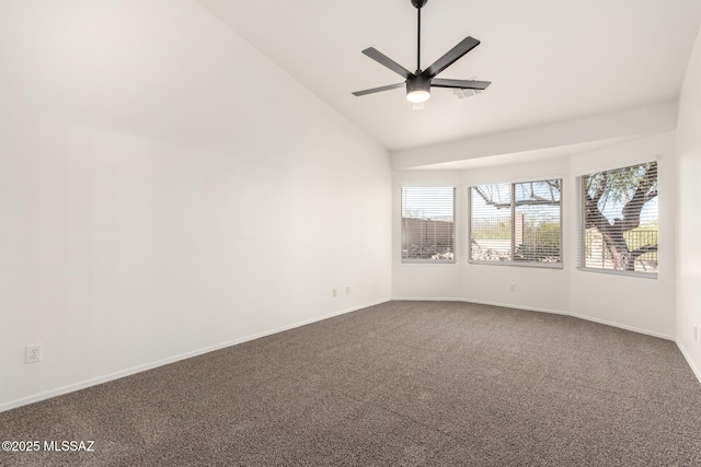 empty room with a ceiling fan, dark carpet, vaulted ceiling, and a wealth of natural light