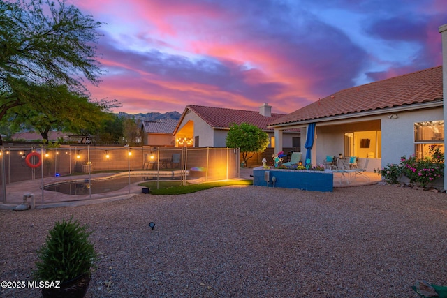 5305 N Via Ln, Doncella, Tucson, AZ 85750 - back of house at dusk featuring a patio, a tiled roof, fence, and stucco siding
