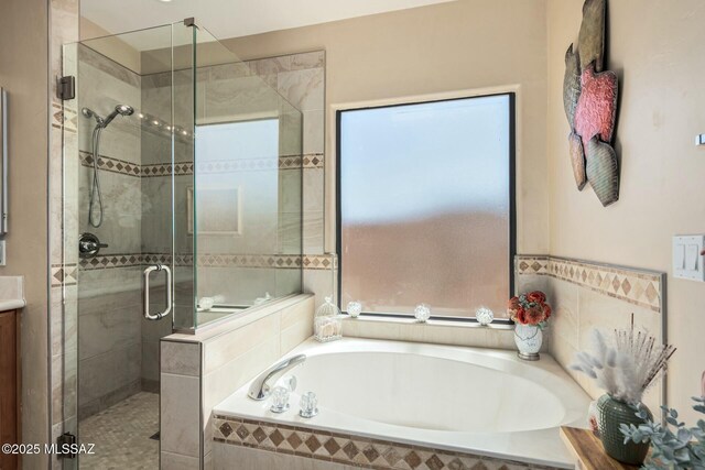 bathroom featuring a shower stall, a bath, and vanity
