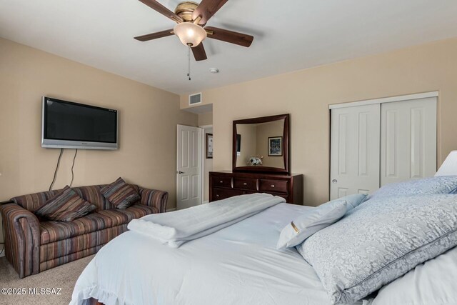 bedroom featuring visible vents, carpet flooring, a ceiling fan, and a closet