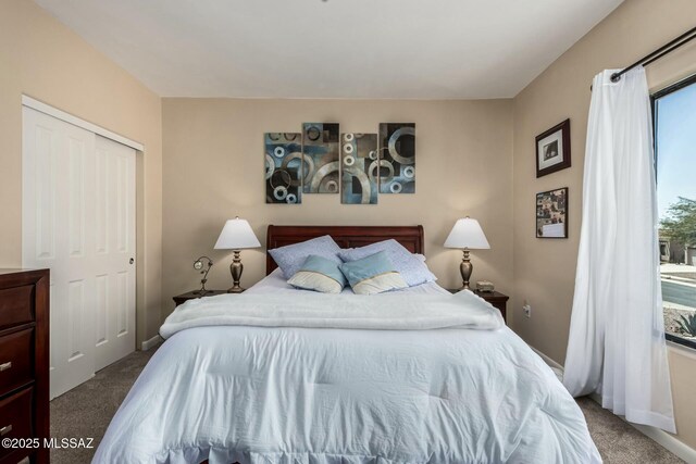 carpeted bedroom featuring baseboards and a closet