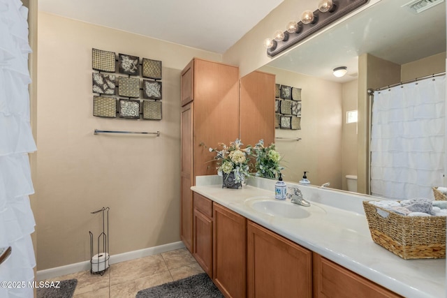 bathroom with visible vents, tile patterned flooring, vanity, baseboards, and toilet