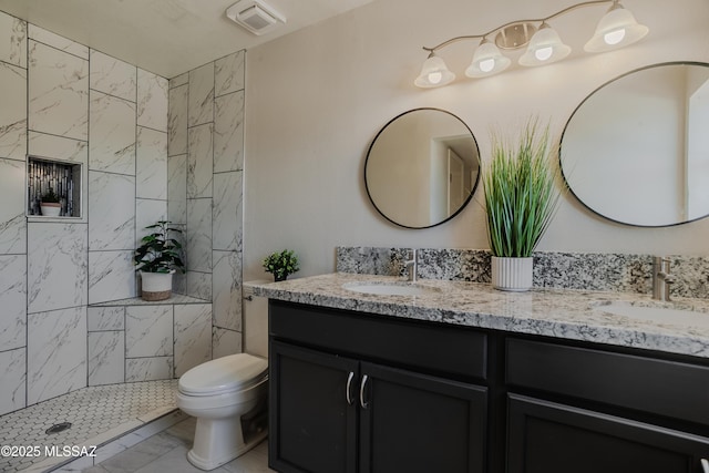 full bathroom with double vanity, toilet, marble finish floor, and a sink