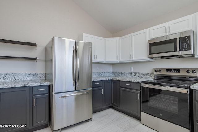 kitchen with appliances with stainless steel finishes, open shelves, white cabinets, and lofted ceiling