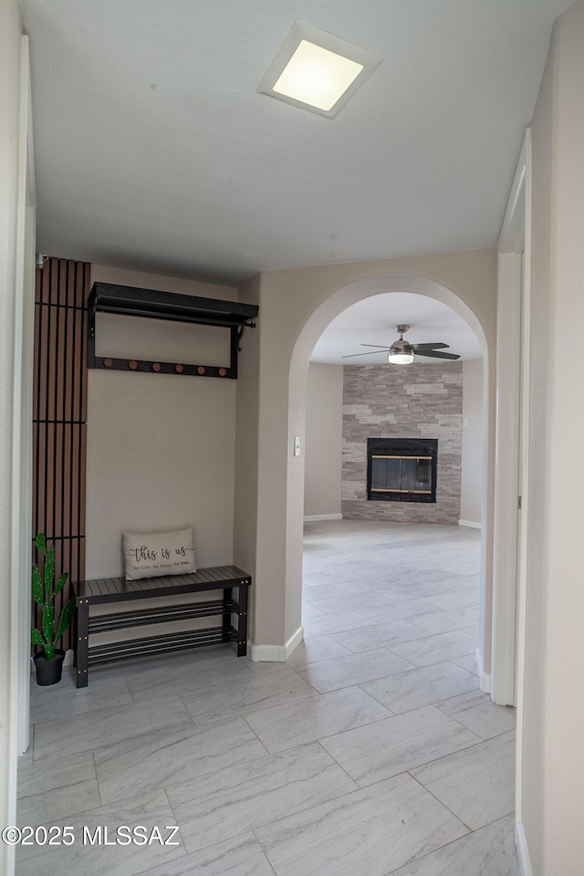 hallway featuring baseboards and arched walkways