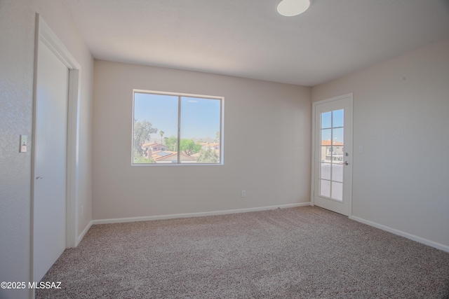 spare room with baseboards, a healthy amount of sunlight, and carpet