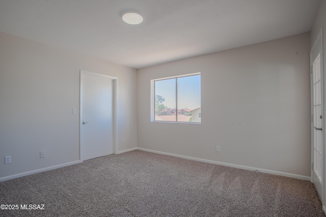 unfurnished room with carpet flooring and baseboards
