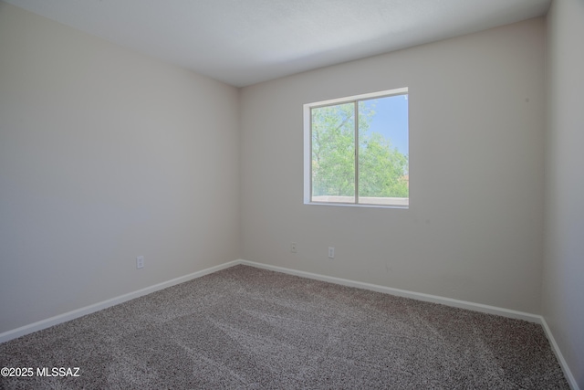 carpeted spare room with baseboards
