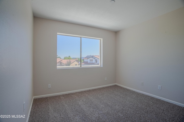 spare room with baseboards and carpet