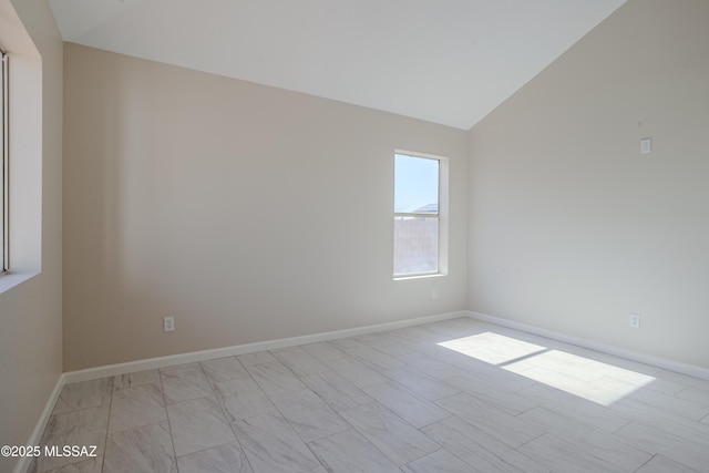 unfurnished room with baseboards and vaulted ceiling