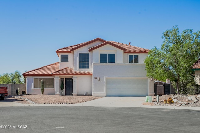 mediterranean / spanish-style home featuring a tile roof, driveway, stucco siding, and an attached garage
