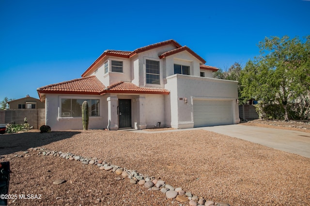 mediterranean / spanish-style home featuring stucco siding, a tiled roof, fence, driveway, and an attached garage