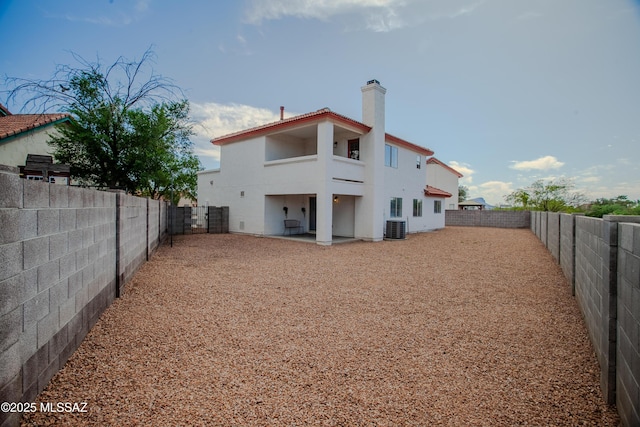 rear view of property featuring a patio, a balcony, a fenced backyard, cooling unit, and stucco siding