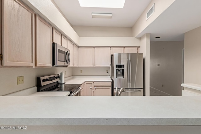 kitchen with visible vents, light countertops, light brown cabinets, and stainless steel appliances