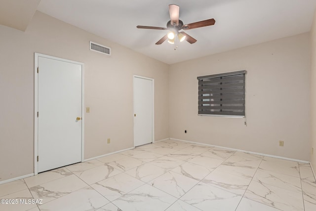 spare room with baseboards, ceiling fan, marble finish floor, and visible vents