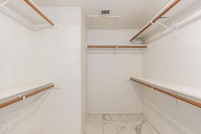 spacious closet featuring visible vents and marble finish floor