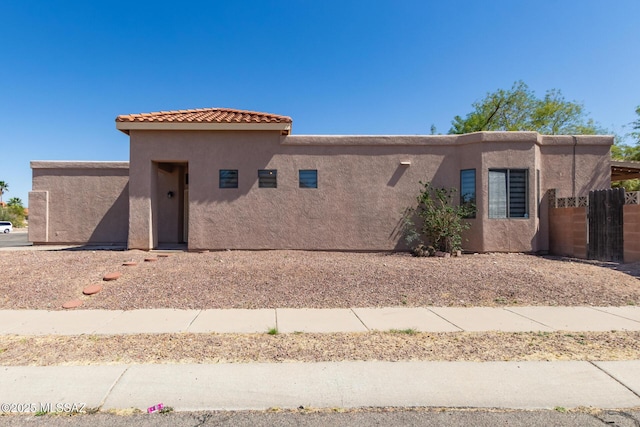 view of front of property featuring stucco siding and fence