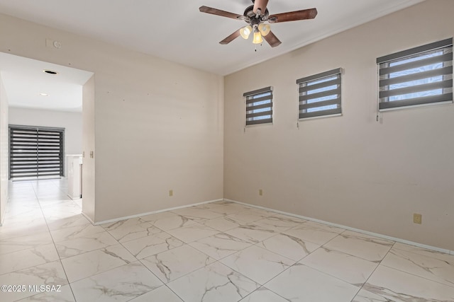 unfurnished room featuring plenty of natural light, ceiling fan, and marble finish floor