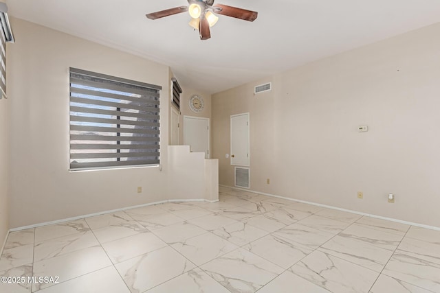 spare room with a ceiling fan, baseboards, visible vents, and marble finish floor