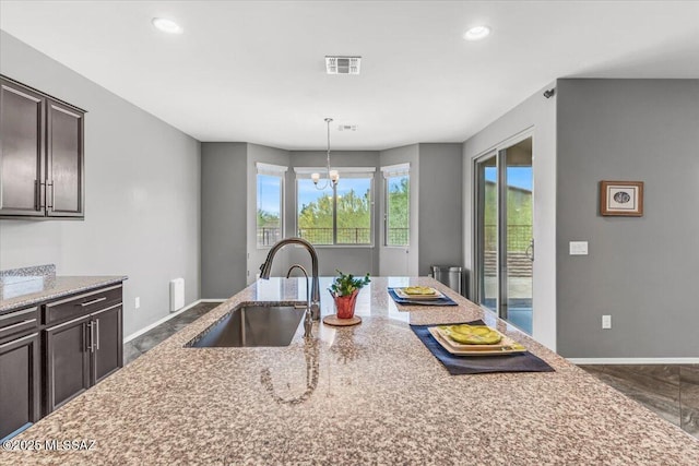 3156 S Three D Ct, Tucson, AZ 85713 - kitchen with a sink, light stone countertops, dark brown cabinets, baseboards, and recessed lighting